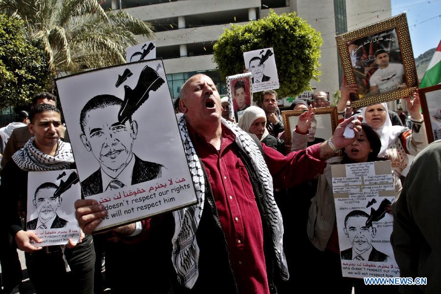 Palestinian protesters hold signs during a protest against the visit of U.S. President Barack Obama in the West Bank city of Nablus on March 21, 2013. Obama arrived in Tel Aviv in Israel Wednesday to start his Mideast tour. Obama will spend three days in Israel, the Palestinian territories and Jordan. (Xinhua/Nidal Eshtayeh)