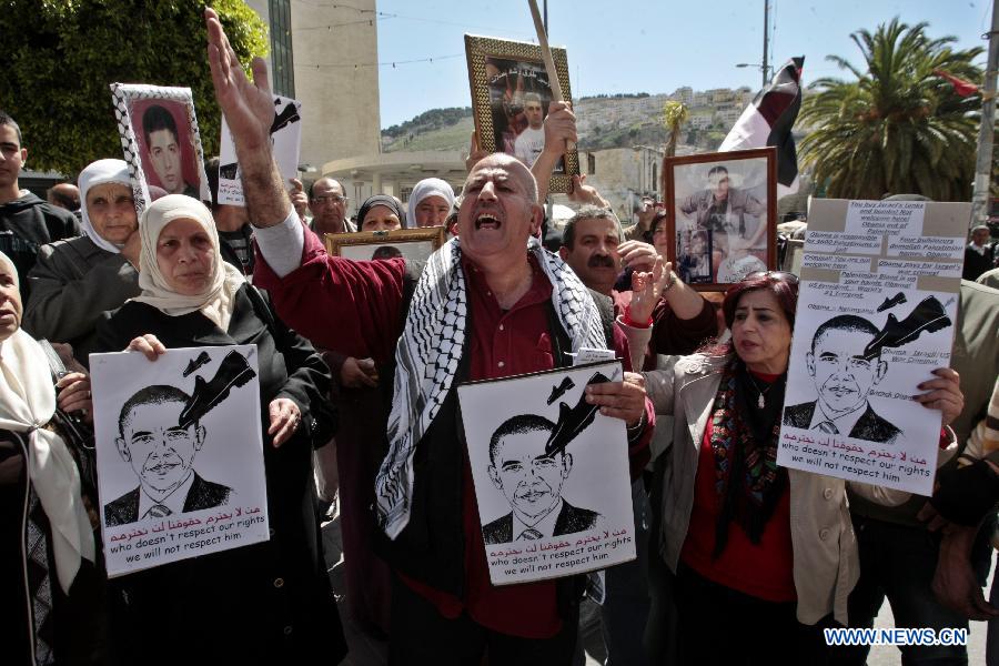 Palestinian protesters hold signs during a protest against the visit of U.S. President Barack Obama in the West Bank city of Nablus on March 21, 2013. Obama arrived in Tel Aviv in Israel Wednesday to start his Mideast tour. Obama will spend three days in Israel, the Palestinian territories and Jordan. (Xinhua/Nidal Eshtayeh)