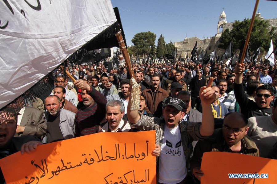 Palestinian protesters hold signs during a protest against the visit of U.S. President Barack Obama in the West Bank city of Bethlehem on March 21, 2013. Obama arrived in Tel Aviv in Israel Wednesday to start his first visit as U.S. president to Israel. Obama will spend three days in Israel, the Palestinian territories and Jordan. (Xinhua/Luay Sababa)