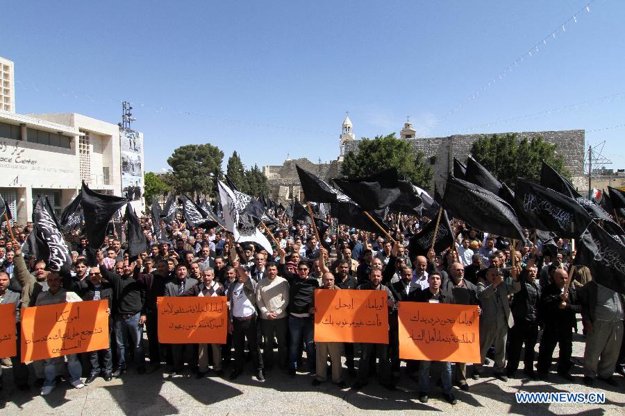 Palestinian protesters hold signs during a protest against the visit of U.S. President Barack Obama in the West Bank city of Bethlehem on March 21, 2013. Obama arrived in Tel Aviv in Israel Wednesday to start his first visit as U.S. president to Israel. Obama will spend three days in Israel, the Palestinian territories and Jordan. (Xinhua/Luay Sababa)