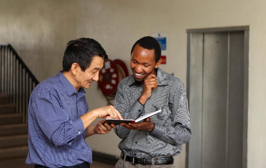 A student of Confucius Institute talks with his teacher outside the classroom at Marien Ngouabi University in Brazzaville, the Republic of Congo, Feb. 26, 2013. In recent years, Africa has witnessed a growing passion for the Chinese language and increasing requests to set up Chinese teaching institutions. To cater to this growing need, China opened the Confucius Institute at the University of Nairobi in 2005, the first of its kind in Africa. The latest figure shows that there are 31 Confucius Institutes and 5 Confucius Classrooms in Africa as of September 2012. (Xinhua/Meng Chenguang)