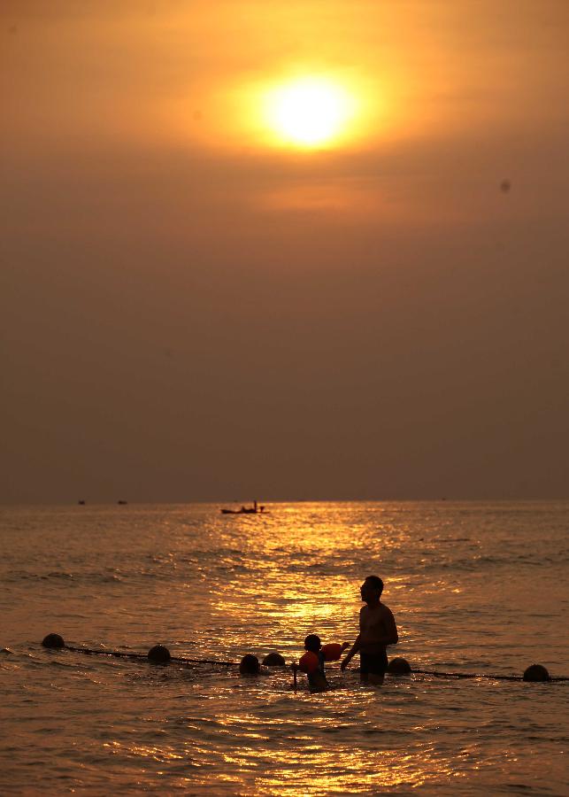 Visitors swim in the sea in Sanya, a tourist destination in south China's Hainan Province, March 20, 2013. (Xinhua/Chen Wenwu) 