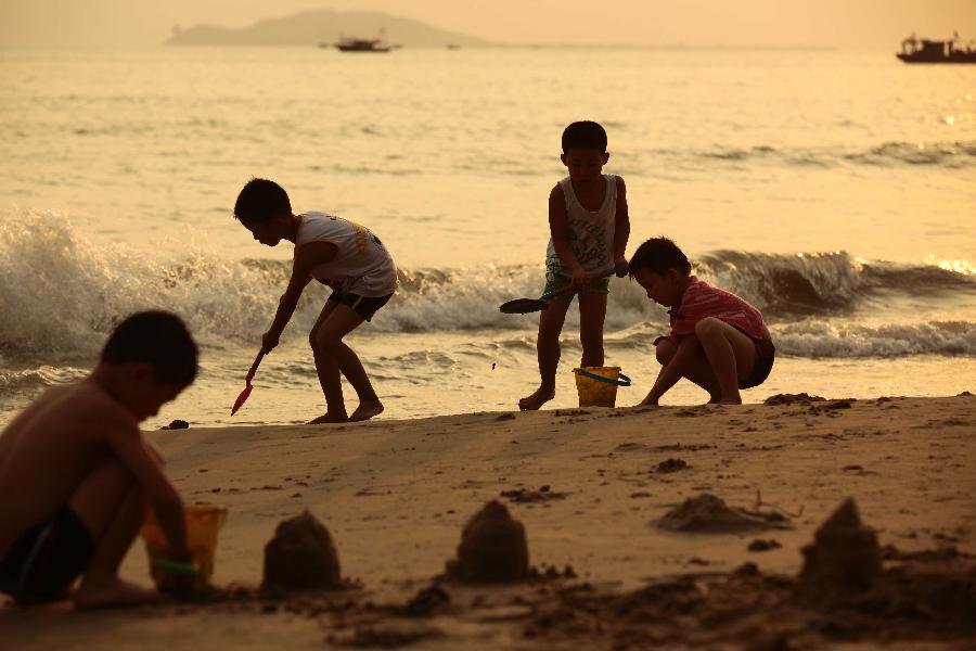 Children play at the seaside in Sanya, a tourist destination in south China's Hainan Province, March 20, 2013. (Xinhua/Chen Wenwu)