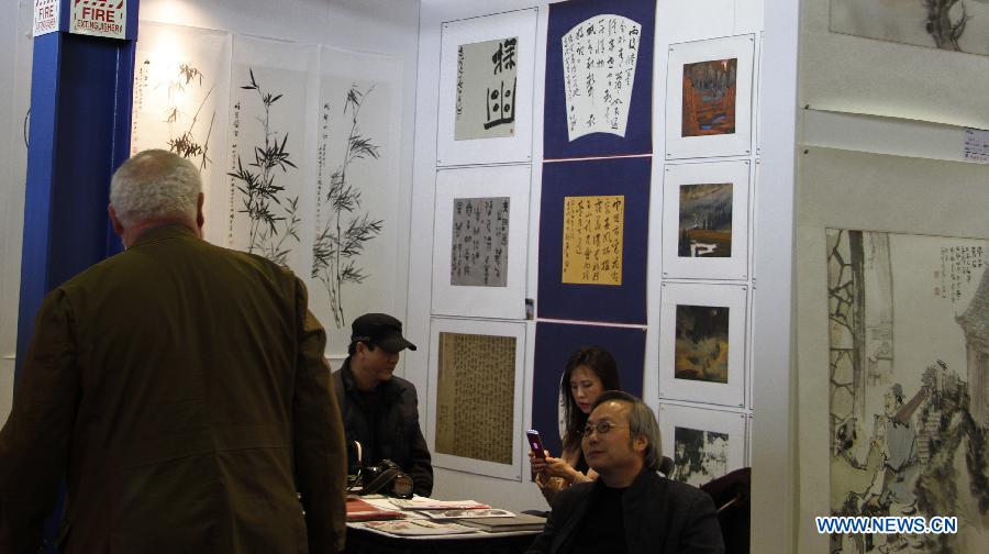 Visitors watch artworks by Chinese artists in New York City, the United States, on March 21, 2013, during the New York Art Expo which is the world's largest fine art trade show for 35 years. (Xinhua/Wang Chengyun) 