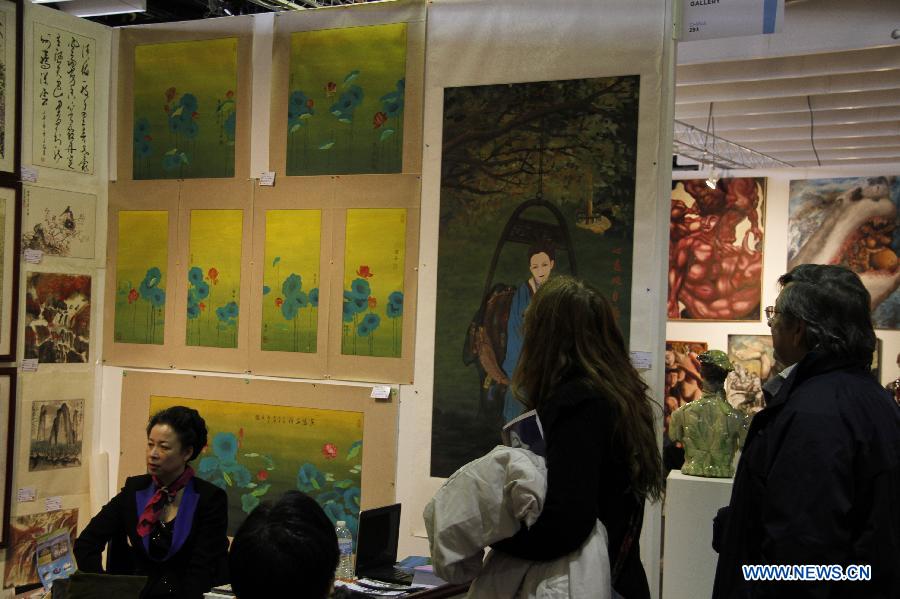 Visitors watch artworks by Chinese artists in New York City, the United States, on March 21, 2013, during the New York Art Expo which is the world's largest fine art trade show for 35 years. (Xinhua/Wang Chengyun) 