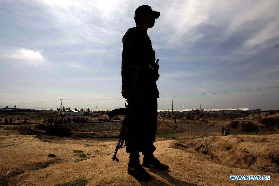 A security official stands guard at the site of a bomb attack at the Jalozai refugee camp in northwest Pakistan's Nowshera on March 21, 2013. At least 12 people were killed and 35 others injured when a bomb hit a refugee camp in Nowshera on Thursday morning, local officials said. (Xinhua Photo/Umar Qayyum)