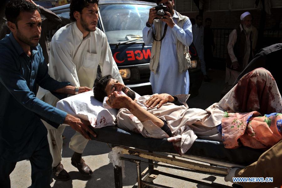 Rescuers transfer an injured man to a hospital in northwest Pakistan's Peshawar on March 21, 2013. At least 12 people were killed and 35 others injured when a bomb hit a refugee camp in Pakistan's northwest city of Nowshera on Thursday morning, local district officials said. (Xinhua/Ahmad Sidique)