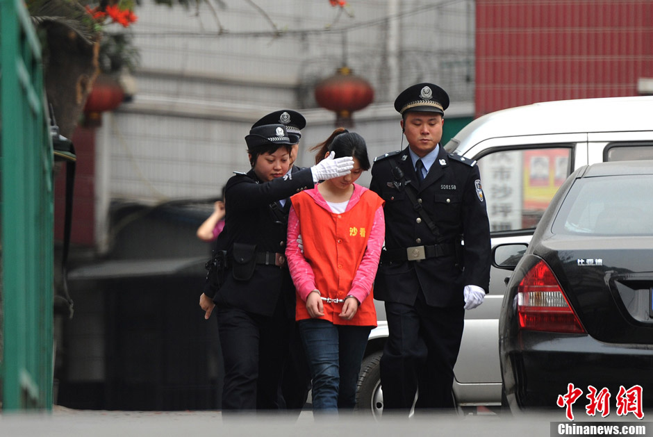 Zhang Guiying is transferred under police escort from Chongqing’s Shapingba District Detention Center on March 22, 2013. Zhang, girlfriend of serial homicidal thief Zhou Kehua, was sentenced to five years in jail on Friday by a court in southwest China's Chongqing Municipality. (Chinanews.com/Chen Chao) 