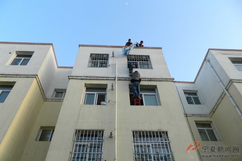 Zhou Bo risks his life to keep posture of lifting for 40 minutes. The boy was rescued by firefighters finally. (Photo/ nxnews.net)