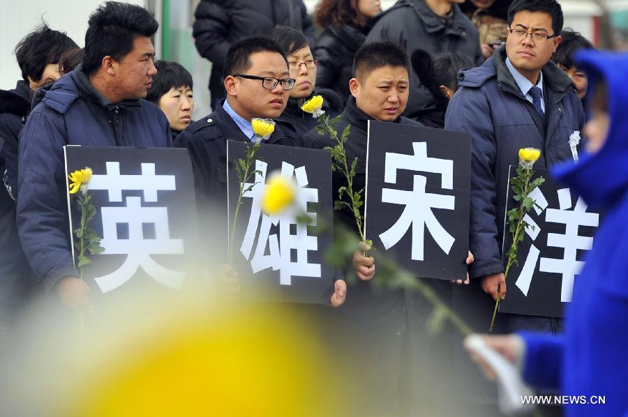 Citizens hold the signs "Hero Song Yang" as they bid farewell to Song Yang, the late bus driver who managed to protect passengers while he was having a stroke, in Jinan, capital of east China's Shandong Province, March 22, 2013. Song experienced a sudden brain hemorrhage while he was driving a long-distance bus carrying 33 passengers on a highway in Chiping County on the morning of March 9. He managed to slow down and park in the highway's breakdown lane, then tried his best to pull the handbrake and turn on the hazard lights. The 34-year-old driver passed away on March 20 despite being treated for days in the hospital. (Xinhua/Guo Xulei)