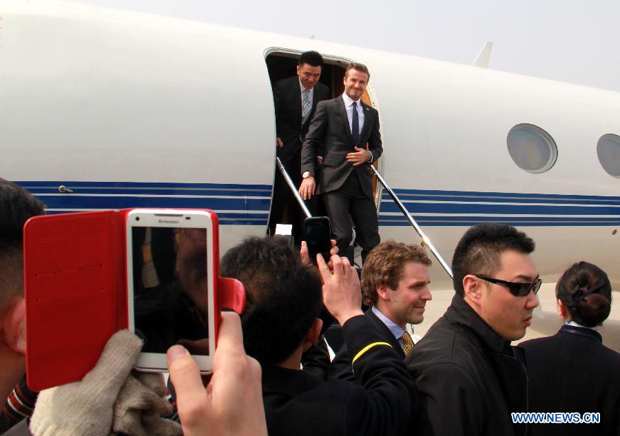 British soccer player David Beckham (rear R) arrives at the Qingdao Liuting Airport in Qingdao, east China's Shandong Province, March 22, 2013. Beckham visited Qingdao Jonoon Soccer Club as the ambassador for the youth football program in China and the Chinese Super League Friday. (Xinhua/Li Ziheng)