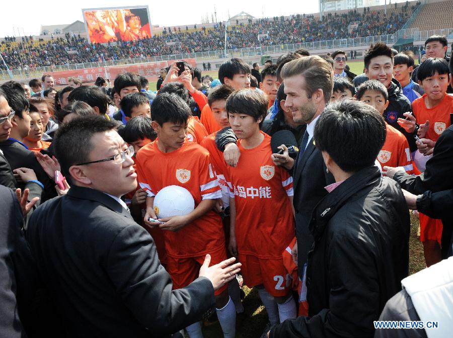 British soccer player David Beckham (C) talks to players of Qingdao Jonoon Soccer Club at the Qingdao Tiantai Stadium in Qingdao, east China's Shandong Province, March 22, 2013. Beckham visited Qingdao Jonoon Soccer Club as the ambassador for the youth football program in China and the Chinese Super League Friday. (Xinhua/Li Ziheng)