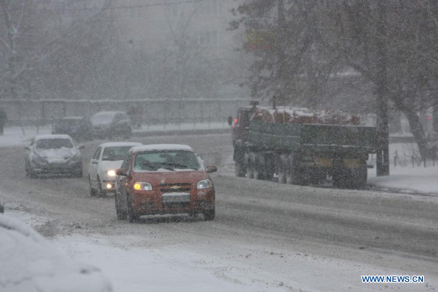 Cars run in snow on a street in Kiev, capital of Ukraine, March 22, 2013. Heavy snow hit Kiev on Friday, disturbing traffic here. (Xinhua/Mu Liming) 