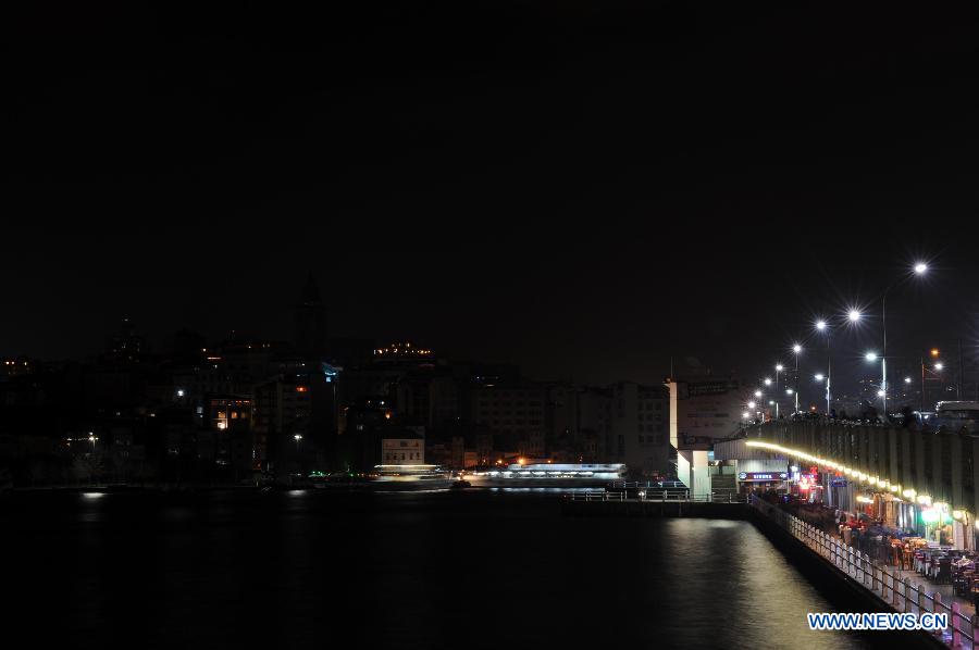 The Galata Tower turns off the lights to mark the annual "Earth Hour" event in Istanbul of Turkey on March 23, 2013. (Xinhua/Ma Yan) 