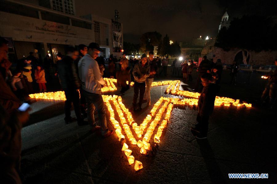 Palestinians gather around candles to mark the "Earth Hour" near the Church of Nativity in the West Bank city of Bethlehem on March 23, 2013. (Xinhua/Luay Sababa) 