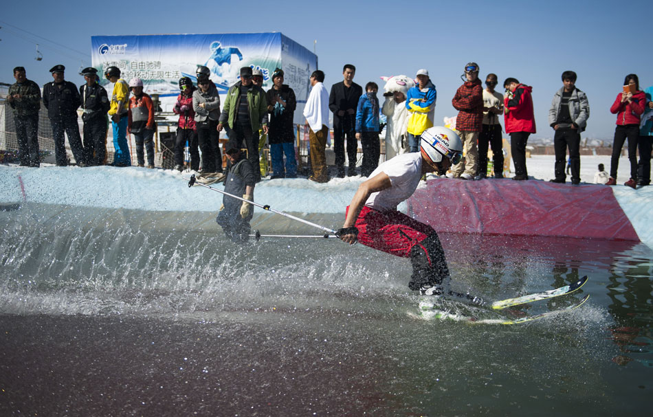 A skier skims over a pool at the end of ski run in Xinjiang, a ritual to say goodbye to winter, March 17, 2013. (Xinhua/Jiang Wenyao)