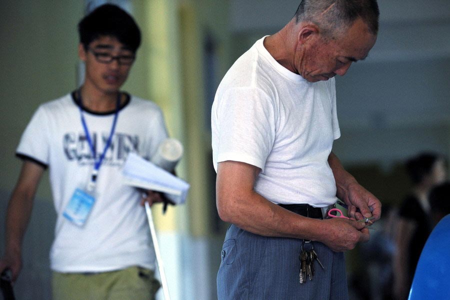 The students' pencils are sharpened by their accompanying parents. (Zhejiang Daily/Chu Yongzhi)