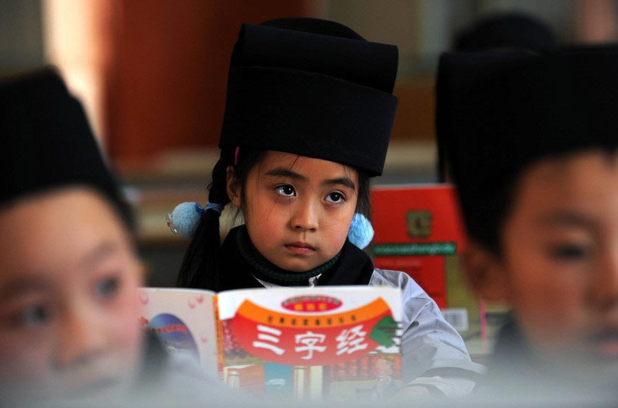 Students at the Jiaxing Elementary Primary School, Zhejiang, dressed in the traditional Chinese Hanfu clothing, follow their teacher to recite the Chinese classics, such as the Three-Character Classic and the Standards for Students, on Mar. 17, 2010. (Zhejiang Daily/Chu Yongzhi)