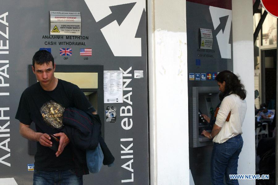 Cypriots use ATMs in Nicosia March 25, 2013. Ordinary Cypriots are numb and worried on the aftermath of the new Eurogroup's agreement, which offers a harsh 10 billion euro bailout deal to Cyprus, including the radical reshaping of the Cypriot banking system. Depositors will lose a large portion of their money exceeding 100,000 euros in the bank. (Xinhua/Marios Lolos) 