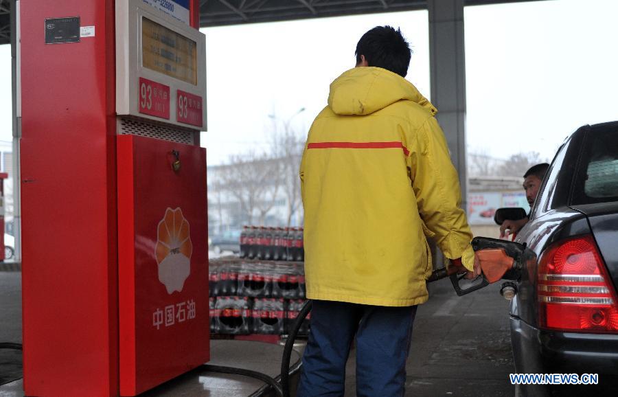 An attendant refuels a car at a gas station in Xingtai, north China's Hebei Province, March 26, 2013. China will cut the retail prices of gasoline by 310 yuan (49.43 U.S. dollars) per tonne and diesel by 300 yuan per tonne starting Wednesday, lowering the retail prices. (Xinhua/Zhu Xudong)