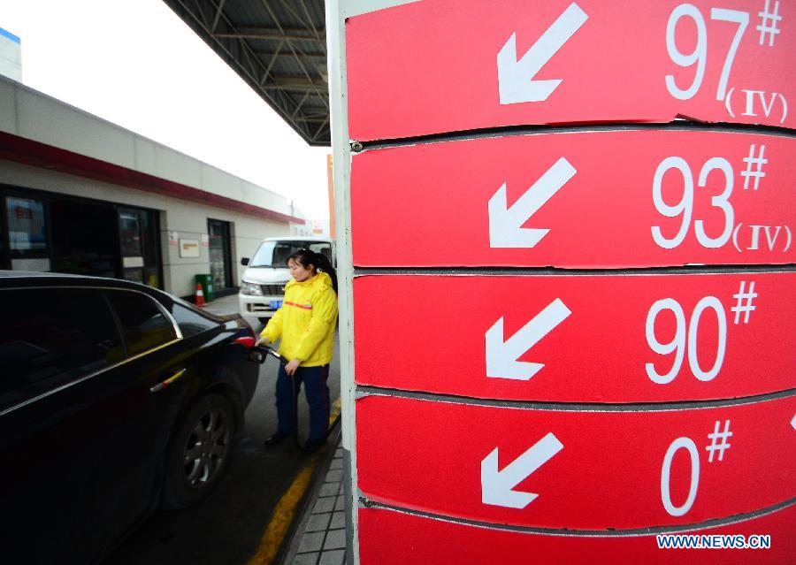 An attendant refuels a car at a gas station in Wuxi, east China's Jiangsu Province, March 26, 2013. China will cut the retail prices of gasoline by 310 yuan (49.43 U.S. dollars) per tonne and diesel by 300 yuan per tonne starting Wednesday, lowering the retail prices. (Xinhua/Huan Yueliang)