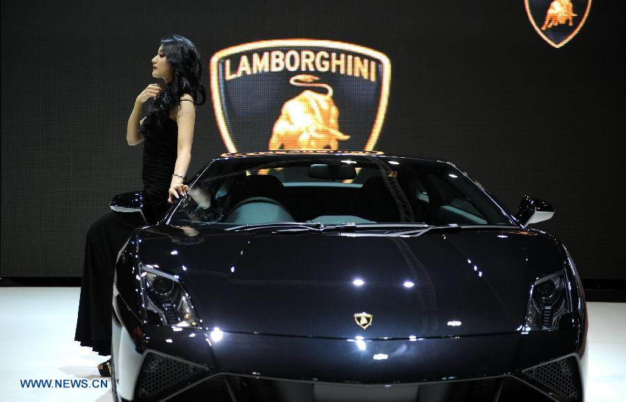 A model pose beside a Lamborghini roadster during the press preview of the 34th Bangkok International Motor Show in Bangkok, Thailand, on March 26, 2013. The 34th Bangkok International Motor Show will be held from March 27 to April 7. (Xinhua/Gao Jianjun)  