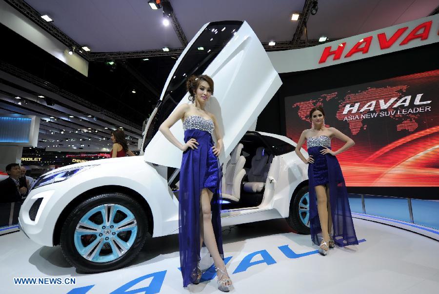 Models pose beside an SUV car of Great Wall Motor during the press preview of the 34th Bangkok International Motor Show in Bangkok, Thailand, on March 26, 2013. The 34th Bangkok International Motor Show will be held from March 27 to April 7. (Xinhua/Gao Jianjun)  