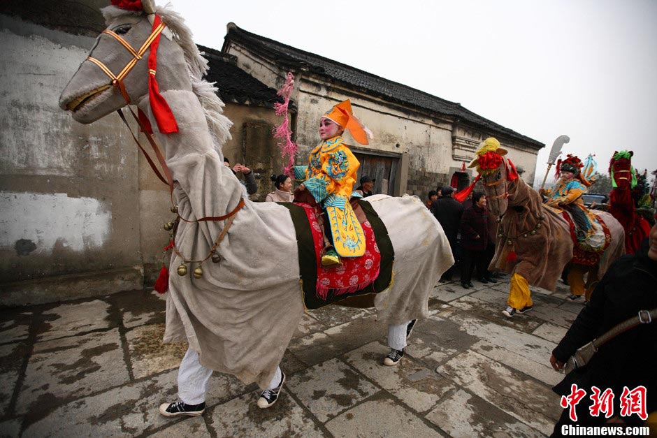 A "horse troop" parade in Qiqiao village of Nanjing attracted villages' attention on March 24, 2013. Big Horse Lantern (Da Ma Deng) is a folk arts form which began in Tang dynasty and got popular in Qing and Ming dynasties. The horse troop consists of seven "horses", and two people dressed as one horse. Child actors dressed up as historical figures, wave flags and whip horses to trot as if they were in the battle. (Xinhua / Yang Bo) 