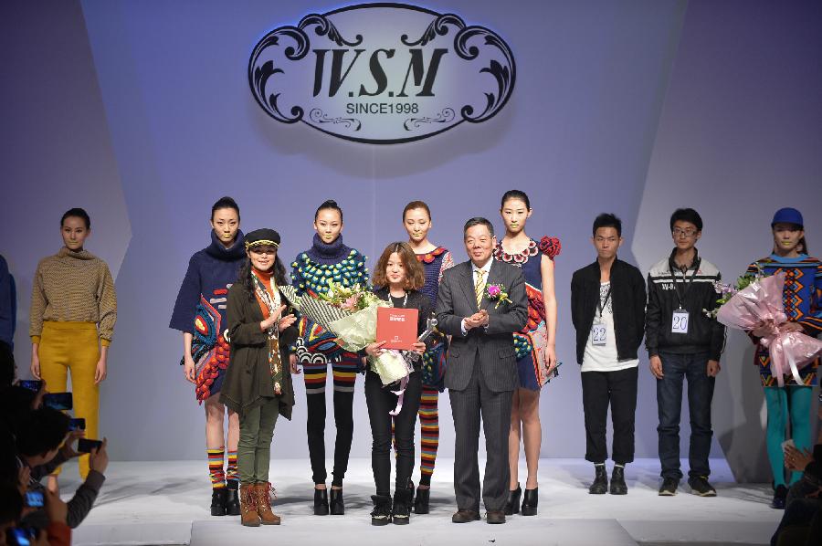 Sheng Lina from Fashion School & Engineering of Zhejiang Sci-Tech University receives the certificate for winning the championship in the WSM China Knitwear Fashion Design Contest 2013 during the China Fashion Week in Beijing, capital of China, March 26, 2013. (Xinhua/Li Xin) 