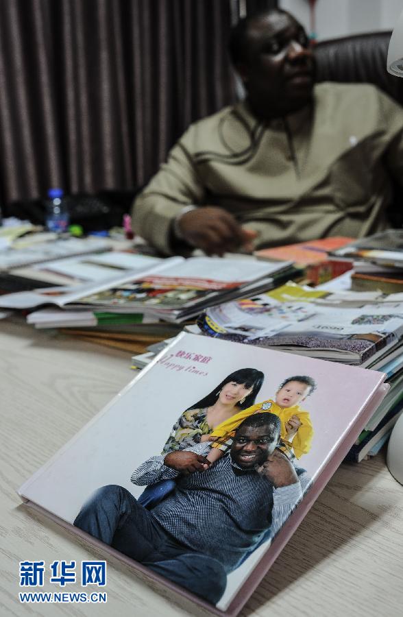 The chairman of the "Nigeria Community" puts his family photo in the office. (Xinhua/ Liu Dawei)