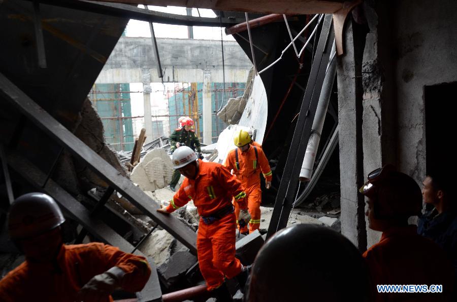 Rescuers search for the trapped workers after a collapse accident happened in a hotel under construction in Zixing City, central China's Hunan Province, March 27, 2013. Two men remained buried in the rubble of a collapsed wall of the hotel. The accident occurred Wednesday morning, when the wall of a dining hall in the hotel collapsed, burying six construction workers. Four workers have been rescued and sent to the hospital, including one worker with serious injuries. (Xinhua/He Maofeng)