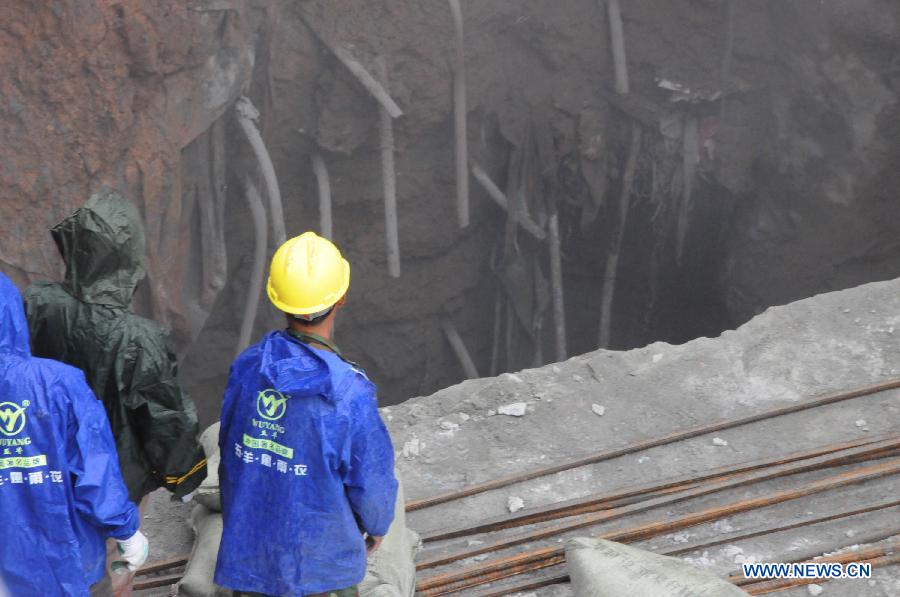 Workers conduct work at a land subsidence accident spot in a community in Futian District of Shenzhen, south China's Guangdong Province, March 27, 2013. A security guard working at the community, who happened to walk past the subsidence area, fell and died. More than 400 families in the community were cut off from water supply due to the accident. (Xinhua/Tian Jianchuan)