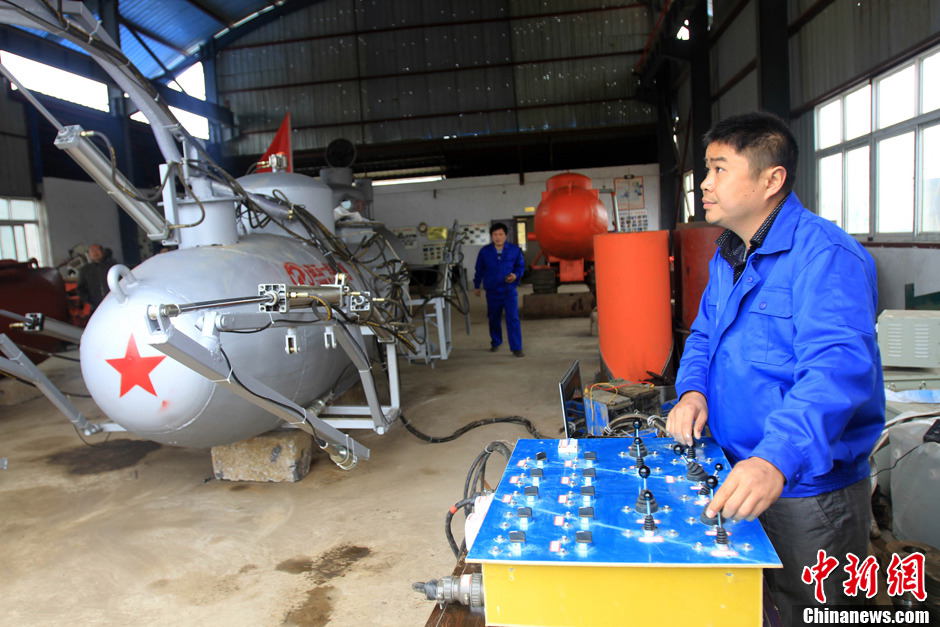 Zhang Wuyi tests his invention, an unmanned underwater fishing device, in Wuhan on March 26, 2013. The “civil submarine” is equipped with a remote control and a camera for picking up image underwater. (Photo by Zhang Chang/ Chinanews.com)