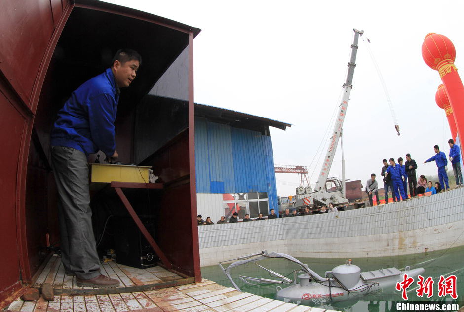 Zhang Wuyi tests his invention, an unmanned underwater fishing device, in Wuhan on March 26, 2013. The “civil submarine” is equipped with a remote control and a camera for picking up image underwater. (Photo by Zhang Chang/ Chinanews.com)