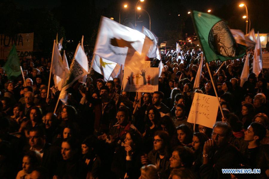 Thousands of Cypriots demonstrate to protest against the harsh treatment imposed on Cyprus by the Eurogroup, in the streets of Nicosia, Cyprus on March 27, 2013. The Mediterranean island and the Troika struck a 10 billion euro bailout deal in Brussels on March 25. The new agreement requires radical reshaping of the Cypriot banking system and massive "haircuts" on Cypriots who have more than 100,000 Euros deposited in banks. Many bank employees may lose their jobs. (Xinhua/Marios Lolos)  