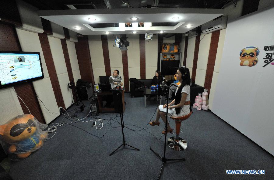 Singer Ren Miaoyin (R) holds a live online concert in Beijing, capital of China, March 21, 2013. (Xinhua/Li Wen) 