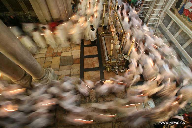 Members of the Catholic clergy hold candles as they take part in a procession at the Catholic Washing of the Feet ceremony in the Church of the Holy Sepulchre in Jerusalem's Old City during Holy Week on March 28, 2013. Holy Week is celebrated in many Christian traditions during the week before Easter. [Photo:Xinhua/Muammar Awad]