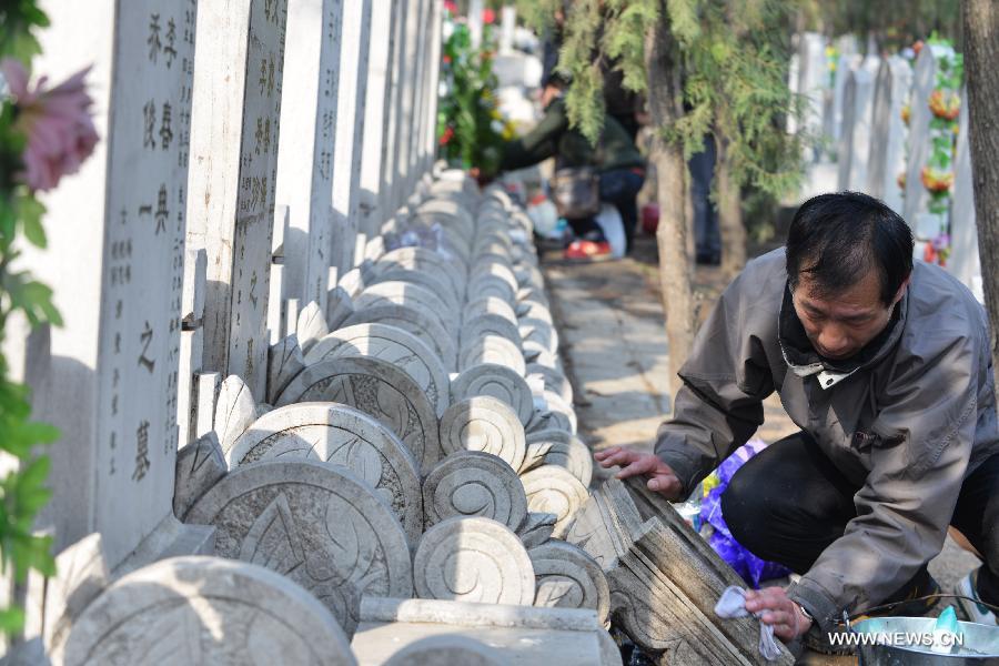 A man cleans his family members' tombstone at the Babaoshan People's Cemetery in Beijing, capital of China, March 30, 2013. Citizens have begun to remember and honour their deceased family members and ancestors as the annual Qingming Festival draws near. The Qingming Festival, also known as Tomb Sweeping Day, is usually observed by the Chinese around April 5 each year. (Xinhua/Wang Quanchao)
