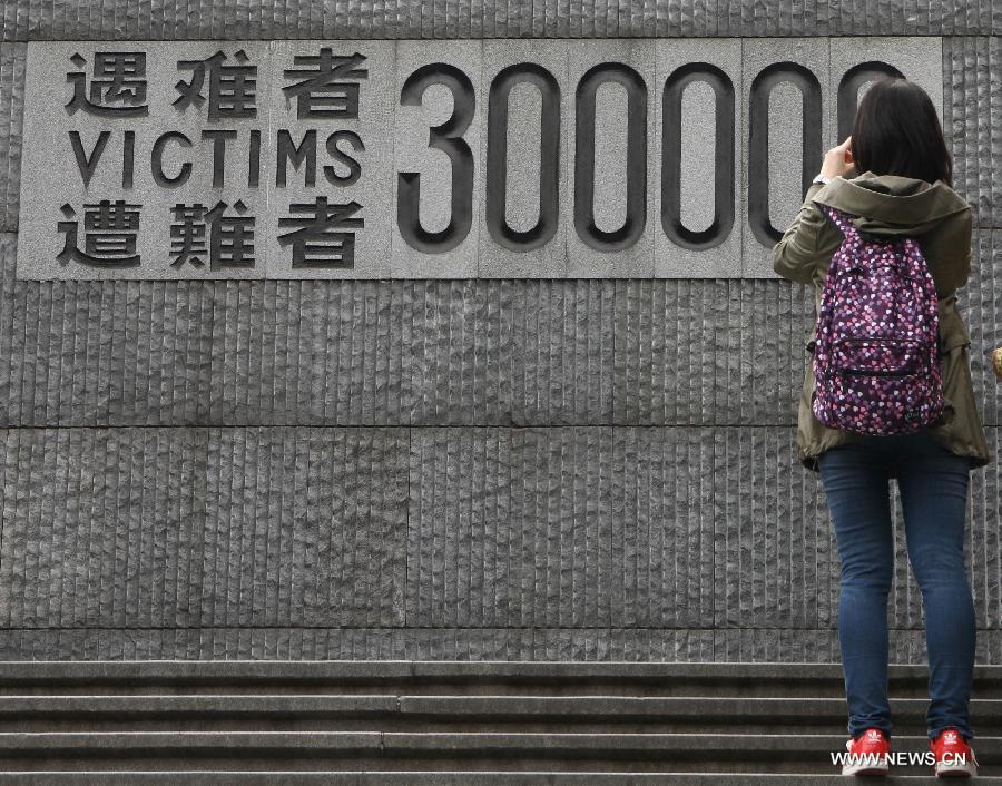 A student takes photos of a memorial wall on which names of the Nanjing Massacre victims are engraved at the Memorial Hall of the Victims in Nanjing Massacre by Japanese Invaders in Nanjing, capital of east China's Jiangsu Province, March 30, 2013, ahead of the Qingming Festival, or Tomb Sweeping Day, which falls on April 4 this year. (Xinhua/Xu Yijia)