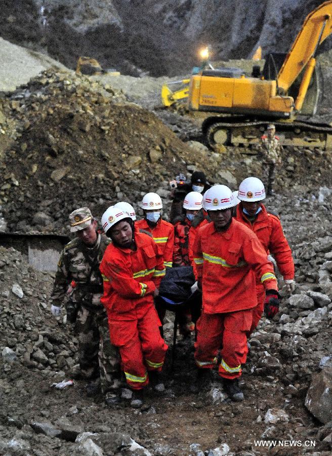 Firefighters carry a body at the site where a large-scale landslide hit a mining area in Maizhokunggar County of Lhasa, southwest China's Tibet Autonomous Region, March 30, 2013. Rescuers have found two bodies and are still searching for survivors more than 37 hours after a massive landslide buried 83 miners at the polymetal mine in Tibet. (Xinhua/Chogo)