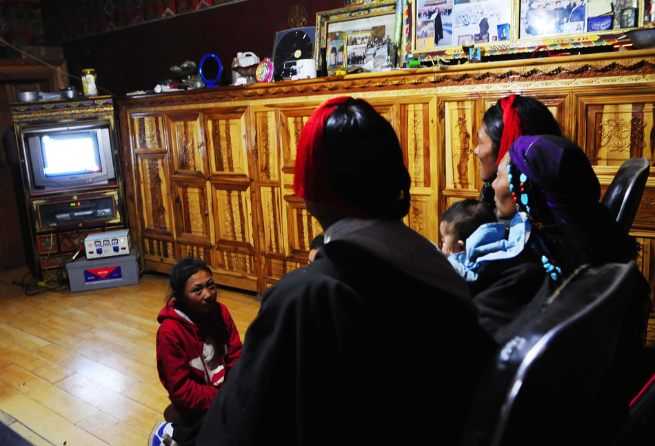 A Tibetan family in a remote village watches TV on March 20, 2013. There were 39 families and 219 people in the village on the plateau 4,300 meters above the sea level. (Xinhua/Liu Kun)