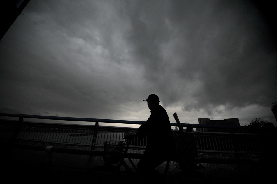 A citizen braves heavy rain and walks in the street of Liuzhou of Guangxi. Sudden rainstorm hit Liuzhou on March 26, 2013. (Xinhua/Li Hanchi)