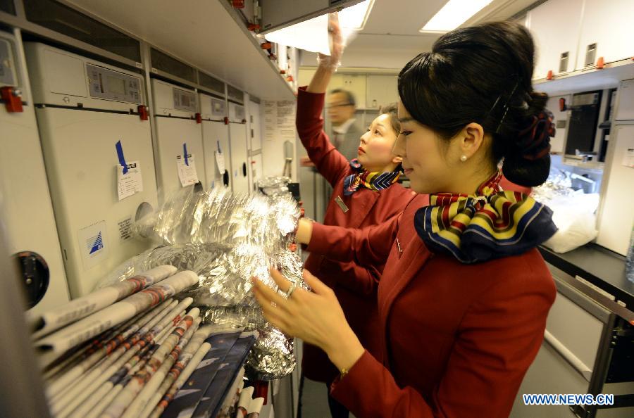 Crew members on the Boeing 777-300ER flying from Beijing prepare food after the plane arrived at the John F. Kennedy International Airport in New York, March 31, 2013. Air China launched its second direct flight between Beijing and New York on Sunday, marking the company's biggest expansion in the U.S. There will be 11 flights plying between Beijing and New York each week and all of them are new Boeing 777-300ERs. (Xinhua/Wang Lei)  