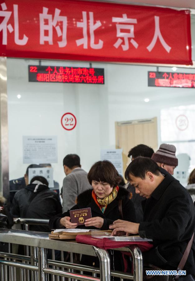 Citizens pay taxes for housing transaction at the Sixth Taxation Office of the Chaoyang District Local Taxation Bureau on the first working day after the Beijing government announced detailed property curbs in Beijing, capital of Beijing, April 1, 2013. The municipal government of Beijing on March 30 spelled out detailed rules aimed at cooling the property market following the central government's fresh regulatory plan earlier this month. Single adults with a permanent Beijing residence registration, who have not made purchases in the city before, are allowed to buy only one apartment, according to the announcement. Meanwhile, the city will raise down payments for second-home buyers and vow to strictly implement the 20-percent tax on capital gains from property sales. (Xinhua/Luo Xiaoguang)