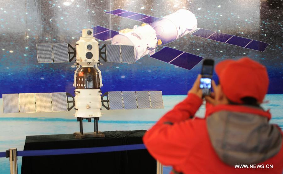 A visitor takes photo during the China's Space Exhibition in Hebei Museum in Shijiazhuang, capital of north China's Hebei Province, April 1, 2013. The exhibition which will last till April 7 included the display of space carriers, rocket-launcher models of the Long March series, paintings and photos related to aerospace. (Xinhua/Wang Xiao)