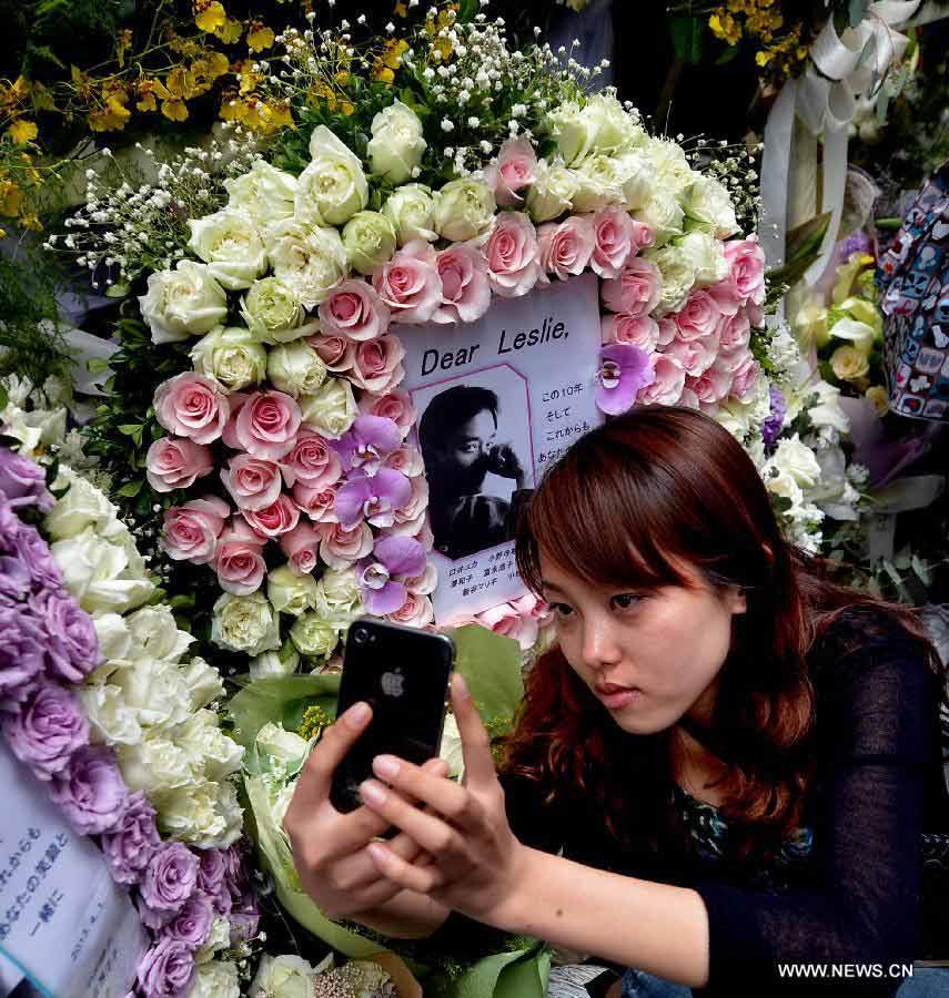 A fan of late Hong Kong singer and actor Leslie Cheung takes a photo of herself at a commemoration of the 10th anniversary of Leslie's death outside the Mandarin Oriental Hotel in Hong Kong, south China, April 1, 2013. Leslie killed himself by leaping off a balcony on the 24th floor of the Mandarin Oriental Hotel on April 1, 2003. (Xinhua/Chen Xiaowei) 