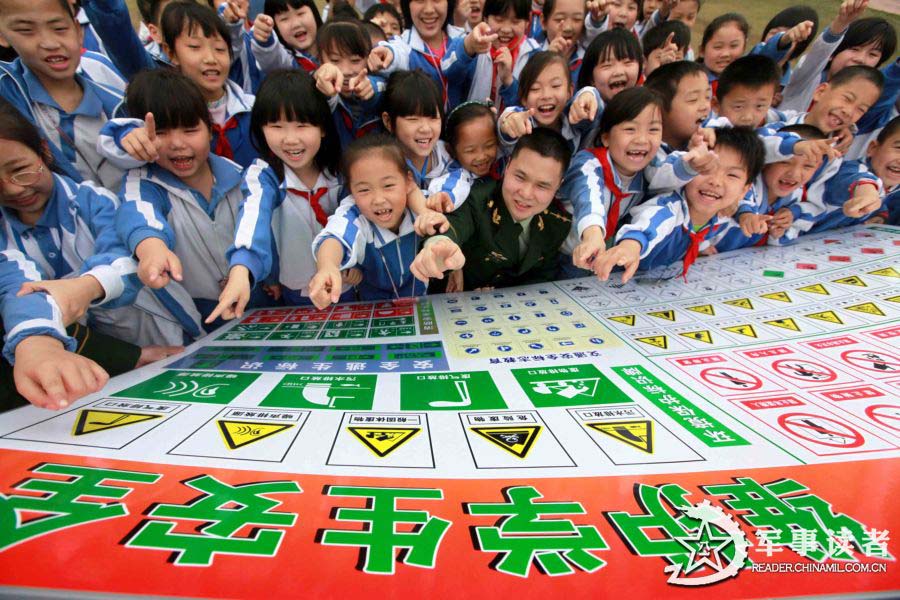 The pupils in the "Golden Fields" Primary School in Shenzhen City learn to identify safety logos on March 25, 2013. The servicemen of the 21st Squadron of the 7th Detachment under the Armed Police Frontier Defense Contingent in Guangdong Province came to the "Golden Fields" Primary School in Shenzhen City on the morning of March 25 to mark the 18th National Safety Education Day for Primary and High School Students together with pupils in the school. (chinamil.com.cn/Zhu Tingwei)