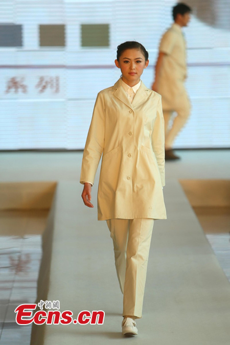 A woman displays a uniform for nurse in Beijing, April 1, 2013. Beijing is planning to change hospital uniforms for doctors, nurses, logistics workers and patients. (photo / CSN)