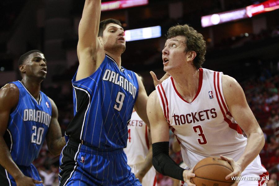 Houston Rockets' Omer Asik (R) tries to break away from Orlando Magic's Nikola Vucevic (C) during their NBA basketball game in Toronto, Canada, April 1, 2013. Rockets won 111-103. (Xinhua/Song Qiong)