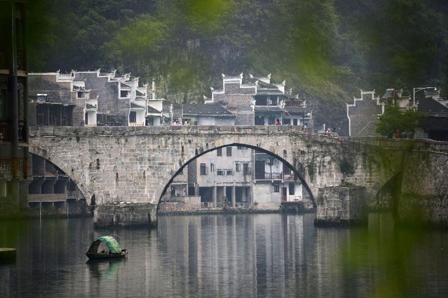 An arch bridge is pictured in Zhenyuan County, southwest China's Guizhou Province, March 31, 2013. The county could date back 2,280 years with the Wuyang River running through it. As many ancient style architectures were built along the river, the ancient town was dubbed as "Oriental Venice" by tourists. (Xinhua/Hu Yan)